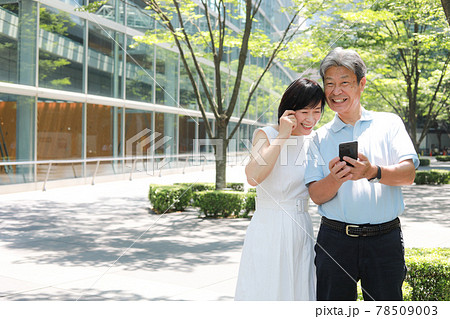 スマホを操作しながら寄り添うシニア夫婦 スマホを操作しながら寄り添うシニア夫婦 78509003