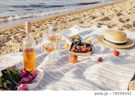 Rose wine, peaches and strawberries on the beach. 78509342