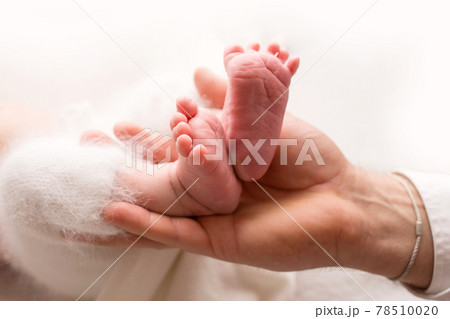 Children's feet in hold hands of mother and father. Mother, father and Child. Happy Family people concept. Children's feet in hold hands of mother and father. Mother, father and Child. Happy Family people concept. 78510020