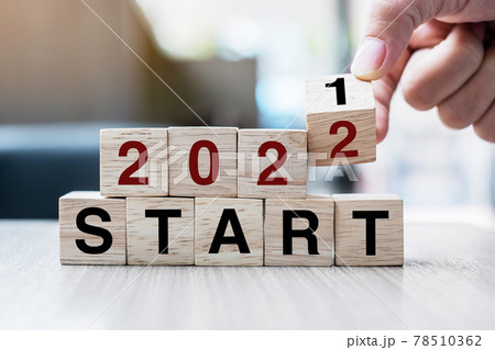 Businessman hand holding wooden cube with flip over block 2021 to 2022 START word on table background. Resolution, strategy, solution, goal, business and New Year holiday concepts 78510362