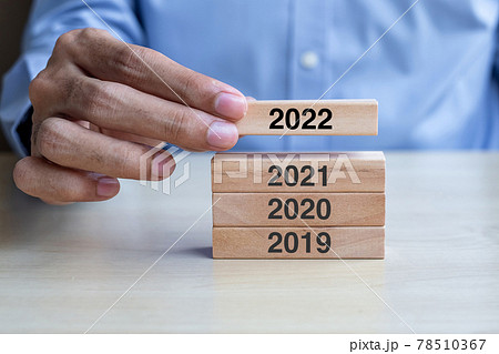 Businessman hand pulling 2022 wooden building blocks on table background. Business planning, Risk Management, Resolution, strategy, solution, goal, New Year New You and happy holiday concepts Businessman hand pulling 2022 wooden building blocks on table background. Business planning, Risk Management, Resolution, strategy, solution, goal, New Year New You and happy holiday concepts 78510367