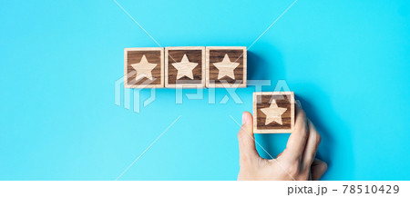 hand holding Star block on blue background. Customer choose rating for user reviews. Service rating, ranking, customer review, satisfaction, evaluation and feedback concept 78510429