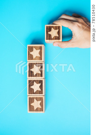 hand holding Star block on blue background. Customer choose rating for user reviews. Service rating, ranking, customer review, satisfaction, evaluation and feedback concept hand holding Star block on blue background. Customer choose rating for user reviews. Service rating, ranking, customer review, satisfaction, evaluation and feedback concept 78510430
