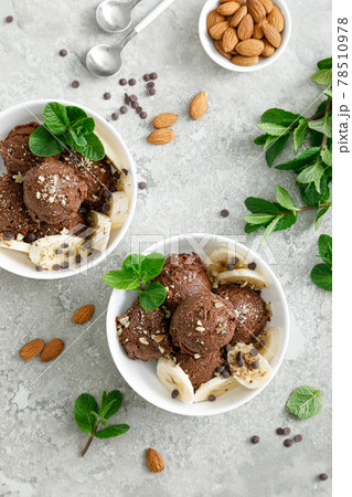 Chocolate and banana fruit ice cream with almond nuts served in bowls, top view 78510978