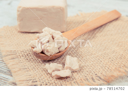 Fresh crumbled yeast on wooden spoon for baking or cooking 78514702