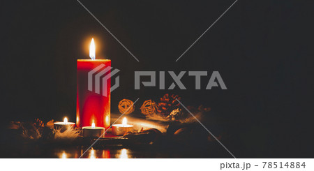 Red Candle with fire against defocused lights in darkness with golden bokeh in the dark Background 78514884
