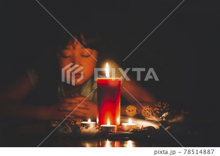 Woman Praying and worship to GOD Using hands to pray in religious beliefs and worship christian with Red Candle with fire against defocused lights in darkness with in the dark Background 78514887