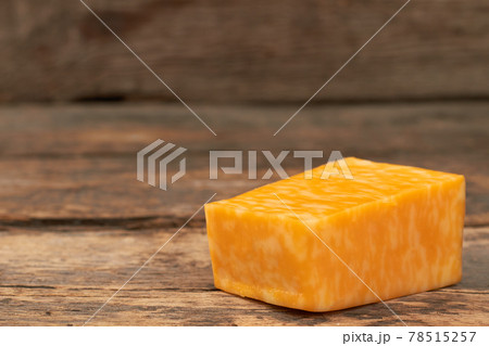 Piece of marble cheese on wooden background. Piece of marble cheese on wooden background. 78515257