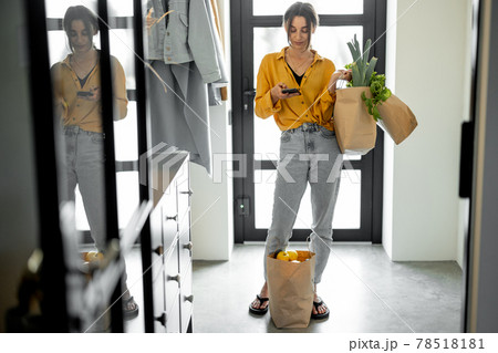 Woman comes home with bags full of fresh groceries Woman comes home with bags full of fresh groceries 78518181