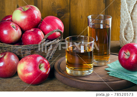Apple juice in glasses and red apples in a basket. 78520573