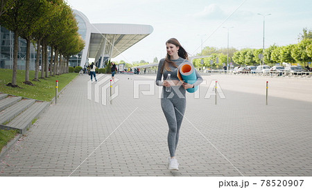 Girl running down stairs in slow motion. Runner woman running on stairs at outdoor workout. Young Sporty Beautiful Girl With A Rug In Her Hands And Water, Running Up The Stairs In The City Center 78520907