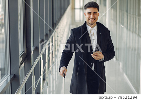Elegant man at the airport with a suitcase 78521294