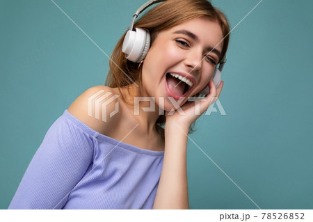 Closeup photo of attractive happy smiling young blonde woman wearing blue crop top isolated over 78526852