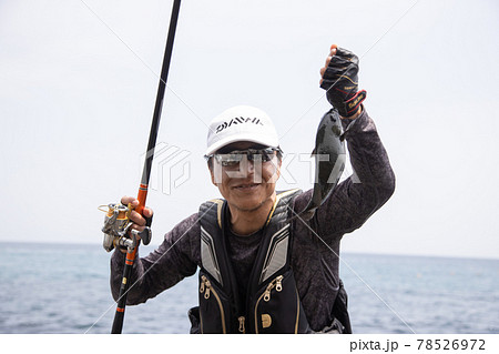 魚釣りでメジナを釣り上げた男性 78526972
