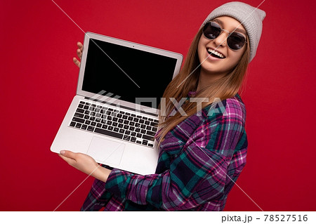 Portrait Photo of beautiful laughing funny smiling blond young woman holding computer laptop with 78527516