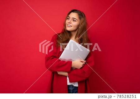 shot of mysterious Beautiful young dark hair curly woman holding close laptop wearing red cardigan 78528251