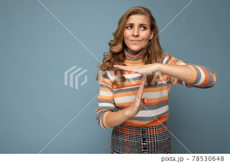 Portrait of sad young beautiful blonde curly woman with sincere emotions wearing stylish striped 78530648