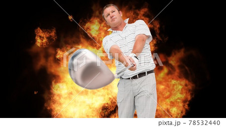Composition of caucasian male golf player holding golf club over flames on black background 78532440