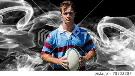 Compostion of caucasian rugby player holding ball on black background with white blur Compostion of caucasian rugby player holding ball on black background with white blur 78532887