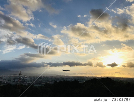 夕焼けの中、飛ぶ飛行機 78533797