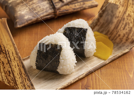竹の皮で包んだおにぎりの弁当 78534162