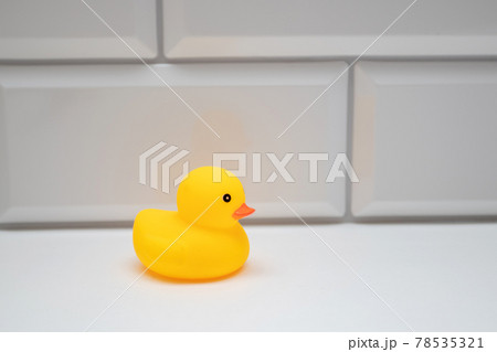 Yellow bath toy duck on a white brick wall in the bathroom Yellow bath toy duck on a white brick wall in the bathroom 78535321