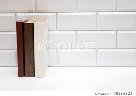 Blank books on white brick wall. Copy space free for text. Blank books on white brick wall. Copy space free for text. 78535322