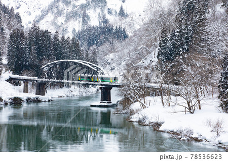 雪景色の中の只見線第四只見川橋梁をわたる列車 78536623