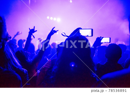 Raised arms holding smart phones to recording a live concert 78536891