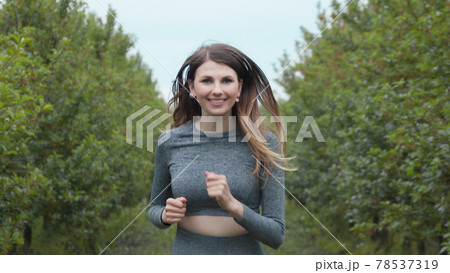 Front Follow up Shot of Girl Athlete Running Alone Down, Getting Ready for a Race Competition or Marathon. Test of Human Endurance. Young Fit Woman in Sportswear Jogging Alone. Slow Motion Front Follow up Shot of Girl Athlete Running Alone Down, Getting Ready for a Race Competition or Marathon. Test of Human Endurance. Young Fit Woman in Sportswear Jogging Alone. Slow Motion 78537319