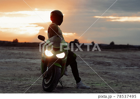 Cool anonymous biker near motorcycle on beach 78537495