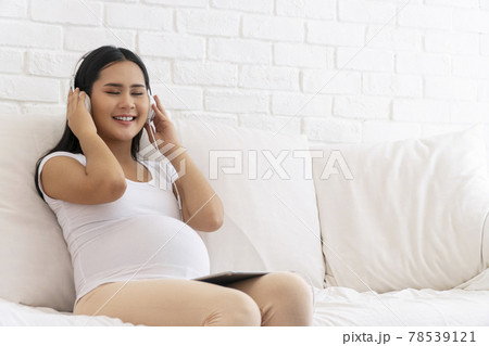 Health care pregnancy concept. Enjoy pregnant young woman wear earphones listening sound music  78539121