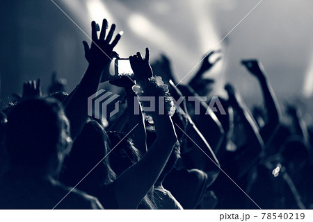 Crowd at a music concert, audience raising hands up, toned 78540219