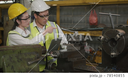 mechanical engineer woman and operation man wearing uniform hardhat and goggles safety working on workshop metal lathe mechanical engineer woman and operation man wearing uniform hardhat and goggles safety working on workshop metal lathe 78540855