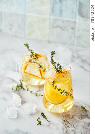 Refreshing cocktail with ice, orange and thyme. Refreshing summer homemade alcoholic or non-alcoholic cocktail or mocktail, or Detox infused flavored water Refreshing cocktail with ice, orange and thyme. Refreshing summer homemade alcoholic or non-alcoholic cocktail or mocktail, or Detox infused flavored water 78542624