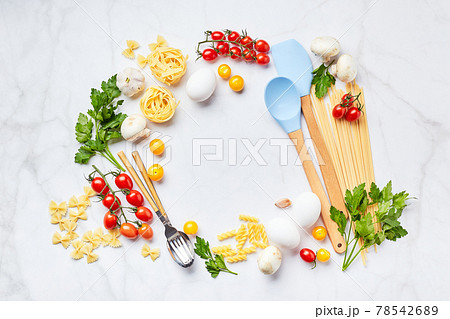Food background with place for text, with different kinds of pasta, tomatoes, herbs, mushrooms, eggs, seasonings scattered on light marble background, top view. Food background with place for text, with different kinds of pasta, tomatoes, herbs, mushrooms, eggs, seasonings scattered on light marble background, top view. 78542689
