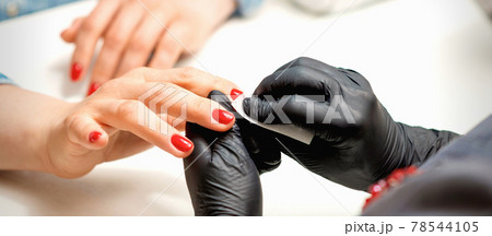 Manicurist wiping nails with napkin 78544105