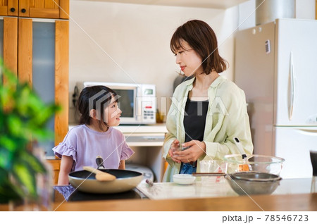 お母さんと一緒に料理をする女の子の写真素材