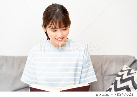 ソファで読書をする若い女性 78547023