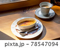 山小屋の窓際のカウンターで、ティーカップに淹れられた一杯のロイヤルミルクティーとクレームブリュレ。 78547094