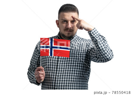 White guy holding a flag of Norway and a finger touches the temple on the head isolated on a white background White guy holding a flag of Norway and a finger touches the temple on the head isolated on a white background 78550418
