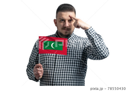 White guy holding a flag of Maldives and a finger touches the temple on the head isolated on a white background White guy holding a flag of Maldives and a finger touches the temple on the head isolated on a white background 78550430