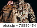 Soldier in gloves holding tactical backpack. 78550454