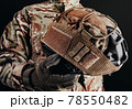 Soldier in gloves holding helmet with cover. 78550482