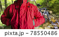 Man standing in travel hiking red jacket in woods. 78550486