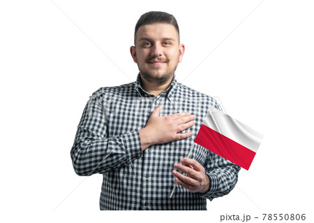 White guy holding a flag of Poland and holds his hand on his heart isolated on a white background With love to Poland White guy holding a flag of Poland and holds his hand on his heart isolated on a white background With love to Poland 78550806