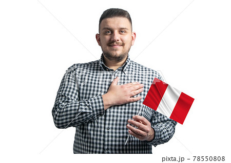 White guy holding a flag of Peru and holds his hand on his heart isolated on a white background With love to Peru 78550808