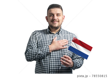 White guy holding a flag of Netherlands and holds his hand on his heart isolated on a white background With love to Netherlands 78550815