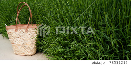 brown wicker bag with green grass in the background brown wicker bag with green grass in the background 78551215