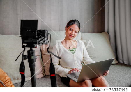 Asian blogger, podcaster or vlogger looking at camera and talking on video shooting with technology Asian blogger, podcaster or vlogger looking at camera and talking on video shooting with technology 78557442